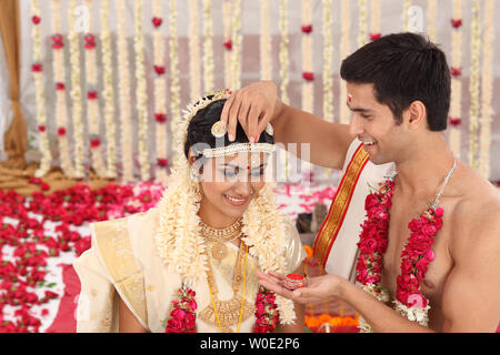 Couple performing Sindoor Daan ceremony in malayalee wedding Stock Photo