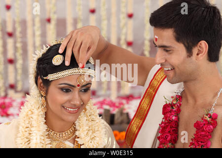 Couple performing Sindoor Daan ceremony in malayalee wedding Stock Photo