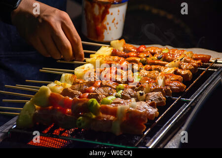 Installations pour Barbecue grillades de viande avec légumes et sauces tomates sur les grilles en acier avec la chaleur. Banque D'Images