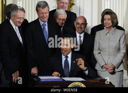 Entouré par les membres du Congrès, le président américain Barack Obama signe le State Children's Health Insurance Program (SCHIP) Le projet de loi dans l'East Room de la Maison Blanche à Washington le 4 février 2009. Le projet de loi élargit le SCHIP par environ 35 milliards de dollars sur cinq ans et sera financée avec un 62-100-par-pack augmentation de la taxe fédérale sur les cigarettes. (Photo d'UPI/Alexis C. Glenn) Banque D'Images