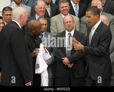 Le président des États-Unis, Barack Obama donne un coup de pouce à l'arrêt-court des Phillies Jimmy Rollins, deuxième à gauche, comme Sonny Rollins donne à Obama une jersey Phillies pendant que Obama se félicite de la Ligue Majeure de Baseball 2008 Champion de la Série mondiale sur les Phillies de Philadelphie portique sud de la Maison Blanche à Washington le 15 mai 2009. À gauche est gestionnaire des Phillies Charlie Manuel. (Photo d'UPI/Roger L. Wollenberg) Banque D'Images