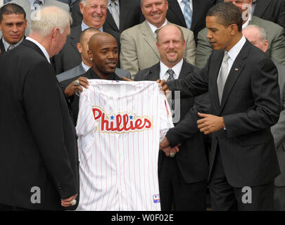 L'arrêt-court des Phillies Jimmy Rollins, deuxième à gauche, donne le président des États-Unis, Barack Obama, un jersey Phillies pendant que Obama se félicite de la Ligue Majeure de Baseball 2008 Champion de la Série mondiale sur les Phillies de Philadelphie portique sud de la Maison Blanche à Washington le 15 mai 2009. À gauche est gestionnaire des Phillies Charlie Manuel. (Photo d'UPI/Roger L. Wollenberg) Banque D'Images