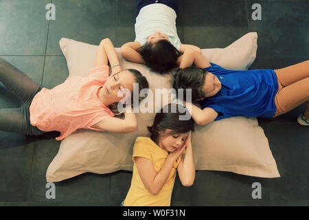 Quatre enfants de dormir sur un grand coussin Banque D'Images