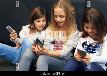 3 filles avec smartphone Banque D'Images