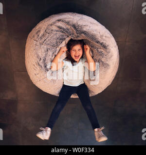 Fille sur un pouf Banque D'Images