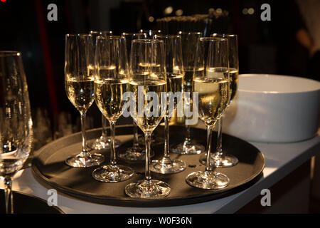 Certaines flûtes en verre rempli de champagne s'illuminé par une lumière douce à partir de l'arrière-plan Banque D'Images