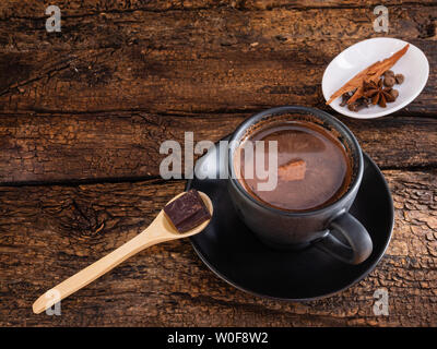 Tasse de chocolat aux épices (cannelle, girofle et ANIS) et mortier sur une authentique ancienne table Banque D'Images