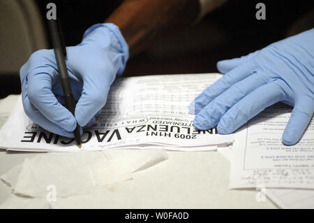 Un agent de santé remplit la paperasse après administration d'une H1N1 la vaccination à Hardy Middle School à Washington le 24 octobre 2009. Le président américain Barack Obama a signé une déclaration d'urgence, autorisant les responsables de la santé à contourner les règles fédérales afin de répondre à l'épidémie de grippe sinus plus rapidement. Plus de 1 000 personnes sont mortes de la grippe H1N1. UPI/Alexis C. Glenn Banque D'Images