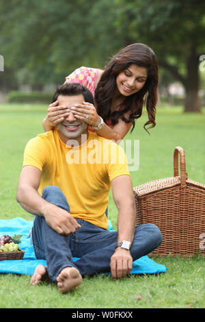 Woman covering man eyes Stock Photo