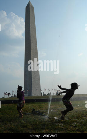 Oli'ka, 6 ans, et ver'ren Scott, l'âge de 4 ans, à partir de Londres, en Angleterre, jouer dans un ensemble de près de le Washington Monument sur le National Mall à Washington, DC, le 7 juillet 2010. La région de métro de DC est à son deuxième jour de températures à trois chiffres comme la côte est en pris dans les griffes de la vague de chaleur. UPI/Alexis C. Glenn Banque D'Images