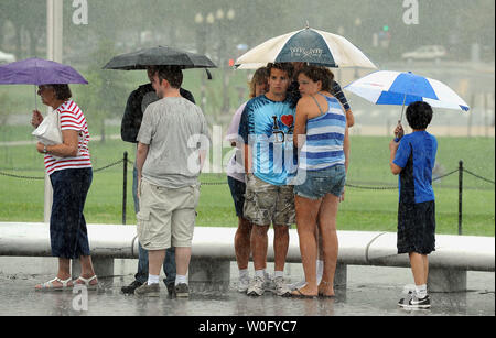 Les touristes attendre sous la pluie pour leur tour pour visiter le Monument de Washington sur le National Mall à Washington le 18 août 2010. Fortes pluies, jusqu'à trois pouces dans certains domaines, inondée et plusieurs automobilistes coincés dans la région de Washington. UPI/Roger L. Wollenberg Banque D'Images