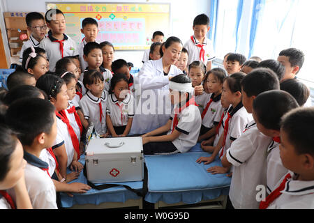 (190627) -- BINZHOU, 27 juin 2019 (Xinhua) -- un travailleur médical scolaire témoigne de compétences en premiers soins aux élèves de l'école primaire n°1 de la ville de Binzhou dans le comté de boxe, la Chine de l'est la province de Shandong, le 27 juin 2019. Activités d'éducation à la sécurité sont organisées dans toute la Chine pour aider à sensibiliser la population étudiante aux questions concernant la sécurité d'un coffre-fort pour les vacances d'été. (Xinhua/Chen Bin) Banque D'Images