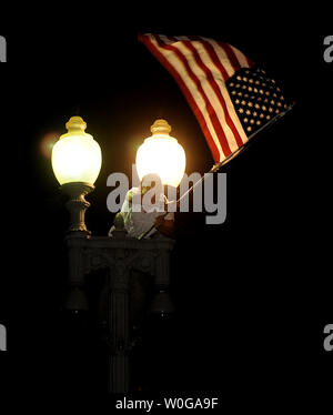 Un jeune homme vagues un drapeau américain à partir d'un pôle de lumière comme des milliers de célébrer la nouvelle que Al-Qaida chef terroriste Oussama ben Laden est mort en face de la Maison Blanche à Washington, DC, le 2 mai 2011. À 11 ce soir le président Obama a annoncé "les États-Unis ont mené une opération qui a tué Oussama ben Laden, le chef d'al Qaïda, et un terroriste qui est responsable du meurtre de milliers d'innocents, hommes, femmes et enfants.' UPI/Roger L. Wollenberg Banque D'Images