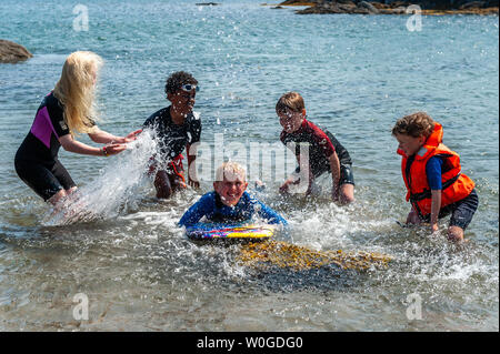 Schull, West Cork, Irlande. 27 Juin, 2019. Sur une journée torride à Schull, beaucoup de gens ont eu la chance d'aller à la plage pour bronzer et nager dans la mer. À la plage ont été Lucy et Daniel Copithorne, Ballydehob ; Ben Gibson et Dylan et Aidan O'Driscoll, tous de Schull. Credit : Andy Gibson/Alamy Live News. Banque D'Images