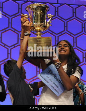 Nandipati Snigdha de San Diego, Californie soulève le trophée du championnat avec l'aide de son frère Sujan (R), elle remporte les deux jours de la Scripps National Spelling Bee Championship, le 31 mai 2012, à National Harbor, Maryland. Nandipati le mot orthographié avec succès * * guetapens, sens d'attirer ou d'embuscade. UPI/Mike Theiler Banque D'Images