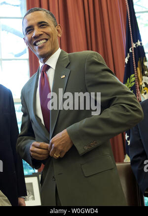 Le président Barack Obama sa veste boutons après la signature de la United States-Israel Loi Renforcement de la coopération en matière de sécurité, qui vous aideront à approfondir notre coopération en matière de sécurité avec Israël, dans le bureau ovale de la Maison Blanche le 27 juillet 2012. UPI/Kevin Dietsch Banque D'Images