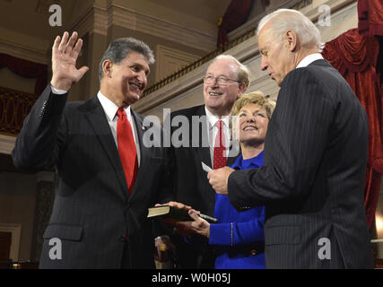 Nouveau réélu Joe Manchin III, (D-WV), (L) met sa main sur une Bible tenu par sa femme Gayle, en tant que collègues Virginie occidentale le sénateur John D. Rockefeller IV témoins, alors qu'il prend part à une reconstitution de son assermentation par le Vice-président Joe Biden (R), dans l'ancienne salle du Sénat au Capitole, le 3 janvier 2013, à Washington, DC. Le sénateur a déjà été officiellement pris sur le parquet du Sénat pour commencer le 113e Congrès. UPI/Mike Theiler Banque D'Images