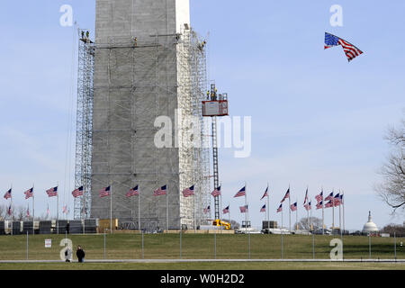 Le Washington Monument est enveloppée d'un échafaudage en tant que visiteur vole un drapeau américain kite (R), le 15 mars 2013. Ce travail commence à réparer les dommages causés par le tremblement de terre de magnitude 5,8 en août 2011 à Washington, DC. Les 555 pieds de Landmark a été fermée depuis lors et les réparations, ce qui devrait prendre plusieurs mois, coûtera 15 millions de dollars. UPI/Mike Theiler Banque D'Images