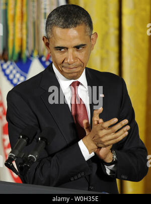 Le président américain Barack Obama salue la visite des anciens combattants de la guerre de Corée au cours d'une cérémonie avec Ray Kapaun, neveu du Père Emil Kapaun, qui a accepté la médaille d'honneur en son nom à titre posthume, dans l'East Room de la Maison Blanche, le 11 avril 2013 à Washington, DC. Père Kapaun, comme aumônier de l'Armée US, administré à des prisonniers de guerre américains lors de la guerre de Corée et mourut en captivité. UPI/Mike Theiler Banque D'Images