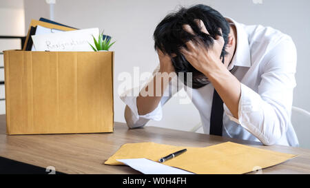 Stressed businessman va être démission et effets personnels d'emballage société et fichiers dans boîte en carton brun, changeant et démissionnera de travail conceptuel Banque D'Images