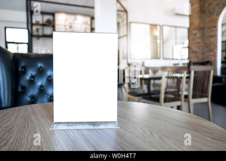 Écran blanc mock up cadre de menu debout sur la table en bois dans le café café et restaurant l'arrière-plan. Banque D'Images