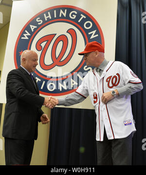 Nationals de Washington Directeur général Mike Rizzo (L) serre la main de Matt Williams, l'équipe de neuf manager, comme il le dit sur un certain nombre 9 jersey, au Championnat National Park, Washington, DC, le 1 novembre 2013. Williams, qui n'a jamais réussi dans les ligues majeures, est un ancien All-Star, jouant principalement pour les Giants de San Francisco et les Diamondbacks de l'Arizona. UPI/Mike Theiler Banque D'Images