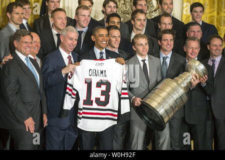 Le président Barack Obama détient un jersey qui lui ont été données par les Blackhawks de Chicago Blackhawks avec Président-directeur général John McDonough (3e-L), le capitaine de l'équipe, Jonathan Toews (5e-R) et le centre Patrick Kane (4e à droite) lors d'un événement où Obama a rendu hommage aux champions de la Coupe Stanley 2013 Blackhawks de Chicago, à la Maison Blanche à Washington le 4 novembre 2013. UPI/Kevin Dietsch Banque D'Images