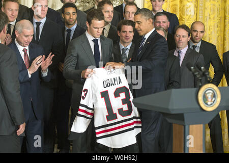 Le président Barack Obama reçoit un chandail de l'équipe des Blackhawks de Chicago le capitaine Jonathan Toews lors d'un événement où Obama a rendu hommage aux champions de la Coupe Stanley 2013 Blackhawks de Chicago, à la Maison Blanche à Washington le 4 novembre 2013. UPI/Kevin Dietsch Banque D'Images