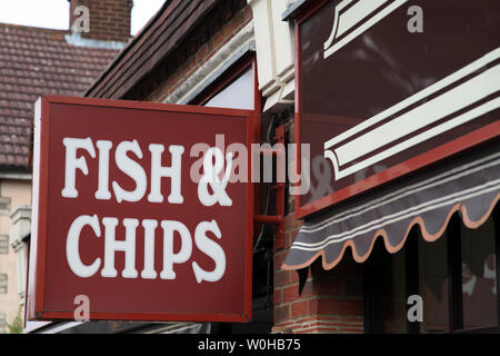 Ashtead, Surrey, UK - signe pour la Fish & Chips, accroché à un mur à l'extérieur Superfish chip shop dans journée Banque D'Images