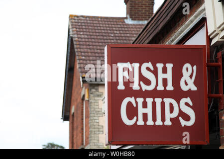 Ashtead, Surrey, UK - signe pour la Fish & Chips, accroché à un mur à l'extérieur Superfish chip shop dans journée Banque D'Images