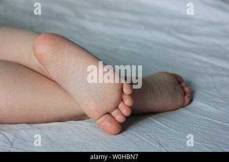 Les pieds du bébé. L'enfant est en train de dormir sur le lit. Libre le pied mignon Banque D'Images