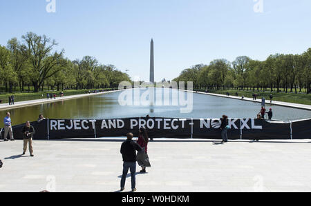 Les protestataires dévoiler une maquette gonflable au cours de pipe-line une protestation contre le pipeline KXL au miroir d'eau sur les ressortissants Mall à Washington, D.C. le 24 avril 2014. Le cow-boy et indien Alliance a organisé le pipeline de sables bitumineux Keystone XL protestation à montrer la nécessité de mettre en évidence les impacts environnementaux possibles du projet. UPI/Kevin Dietsch Banque D'Images