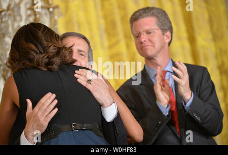 La Première Dame Michelle Obama hugs Secrétaire par intérim VA Sloan Gibson comme logement et des Affaires urbaines, Shaun Donovan Secrétaire applaudit lors d'un événement d'annoncer "Le défi des maires pour mettre fin à l'itinérance, l'ancien combattant' dans le cadre de l'initiative de réunir les forces, à la Maison Blanche, à Washington, D.C. le 4 juin 2014. UPI/Kevin Dietsch. Banque D'Images