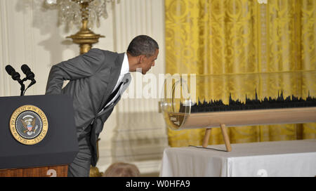 Le président des États-Unis, Barack Obama, se penche sur un modèle 3-D de son état de l'Union qu'il fait les remarques sur la Maison Blanche Maker Faire dans la East Room, le 18 juin 2014, à Washington, DC. Le faire est une série de projets par les étudiants, les entrepreneurs et les citoyens ordinaires à l'aide de nouvelles technologies et d'outils pour lancer de nouvelles entreprises et l'apprentissage de nouvelles compétences en sciences, technologie, ingénierie et mathématiques. UPI/Mike Theiler Banque D'Images