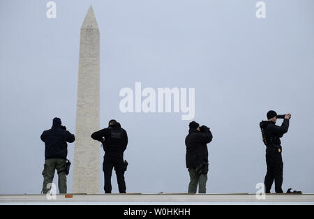 Les membres du Service Secret utiliser des jumelles à fort grossissement en tant qu'ils gardent sur la surveillance Ellipse avec le Washington Monument dans le fond, avant l'arrivée du président américain Barack Obama et la première famille à participer à l'illumination de l'arbre de Noël National, le 4 décembre 2014, à Washington, DC. La tradition a été créée en 1923 par le Président Calvin Coolidge et historiquement commence la période des Fêtes dans la capitale américaine. UPI/Mike Theiler Banque D'Images