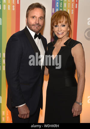 Actrice et chanteuse country Reba McEntire (R) et son mari Narvel Blackstock poser pour les photographes sur le tapis rouge à leur arrivée pour une soirée de divertissement de gala au Kennedy Center, le 7 décembre 2014, à Washington, DC. Le Kennedy Center Honors sont remis chaque année sur cinq artistes pour leur l'ensemble de ses réalisations dans le domaine des arts et de la culture. UPI/Mike Theiler Banque D'Images