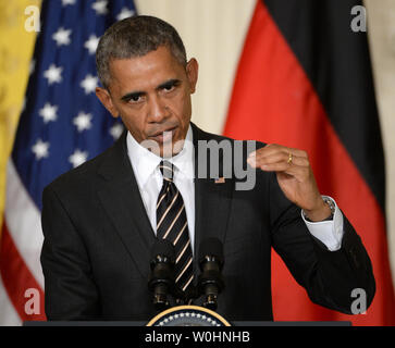 Flanqué de drapeaux américains et de l'Allemagne, le président américain Barack Obama fait un point lors d'une conférence de presse commune avec la Chancelière allemande Angela Merkel, à l'Est Chambre à la Maison Blanche à Washington, le 9 février 2015. Merkel et Obama ont discuté de la situation de l'Ukraine, l'Iraq pourparlers nucléaires et d'autres problèmes du monde. Photo de Pat Benic/UPI Banque D'Images