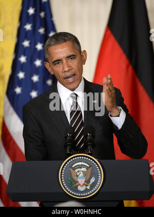 Flanqué de drapeaux américains et de l'Allemagne, le président américain Barack Obama fait un point lors d'une conférence de presse commune avec la Chancelière allemande Angela Merkel, à l'Est Chambre à la Maison Blanche à Washington, le 9 février 2015. Merkel et Obama ont discuté de la situation de l'Ukraine, l'Iraq pourparlers nucléaires et d'autres problèmes du monde. Photo de Pat Benic/UPI Banque D'Images