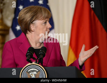 Flanqué de drapeaux américains et de l'Allemagne, la chancelière allemande Angela Merkel reporte au président américain Barack Obama lors d'une conférence de presse commune à l'Est Chambre à la Maison Blanche à Washington, le 9 février 2015. Merkel et Obama ont discuté de la situation de l'Ukraine, l'Iraq pourparlers nucléaires et d'autres problèmes du monde. Photo de Pat Benic/UPI Banque D'Images