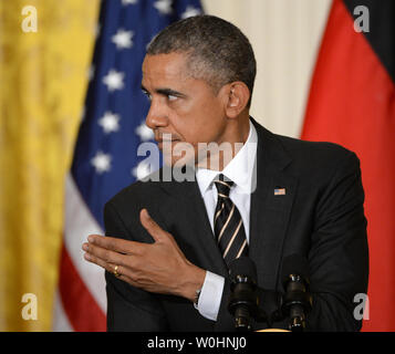 Flanqué de drapeaux américains et de l'Allemagne, le président américain Barack Obama s'en remet à la Chancelière allemande Angela Merkel lors d'une conférence de presse commune à l'Est Chambre à la Maison Blanche à Washington, le 9 février 2015. Merkel et Obama ont discuté de la situation de l'Ukraine, l'Iraq pourparlers nucléaires et d'autres problèmes du monde. Photo de Pat Benic/UPI Banque D'Images