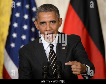 Flanqué de drapeaux américains et de l'Allemagne, le président américain Barack Obama fait un point lors d'une conférence de presse commune avec la Chancelière allemande Angela Merkel, à l'Est Chambre à la Maison Blanche à Washington, le 9 février 2015. Merkel et Obama ont discuté de la situation de l'Ukraine, l'Iraq pourparlers nucléaires et d'autres problèmes du monde. Photo de Pat Benic/UPI Banque D'Images