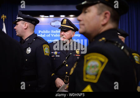 Le sergent de police de Watertown. Jeffrey Pugliese (C) attend avec ses collègues policiers avant le début de la Médaille de bravoure cérémonie de remise de prix à l'Eisenhower Executive Office Building à Washington, D.C. le 11 février 2015. Pugliese et ses collègues policiers sont reconnus pour leur bravoure dans la réponse à l'attentat du Marathon de Boston 2013. Photo par Kevin Dietsch/UPI Banque D'Images