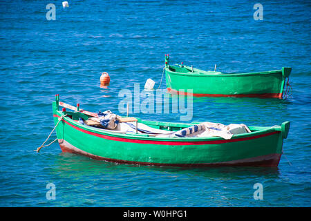 Paire de très beaux vieux rouge et vert en bois de pêche bateaux sur l'eau Banque D'Images