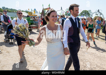 Somerset, Royaume-Uni. 27 Juin, 2019. Somerset, Royaume-Uni. Jeudi 27 juin 2019. Un couple célébrant de mariage il existe à Glastonbury Festival à la ferme digne dans Pilton au 49e festival - qui pourrait être plus chauds jamais, Crédit : Jason Richardson/Alamy Live News Banque D'Images