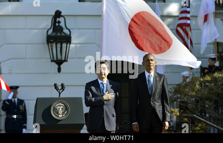 Le Premier ministre japonais Shinzo Abe (L) tient sa main sur son cœur comme le président des États-Unis, Barack Obama, s'établit à l'attention pendant la lecture de l'hymne national japonais une cérémonie de bienvenue à la Maison Blanche, le 28 avril 2015, à Washington, DC. Photo de Mike Theiler/UPI Banque D'Images