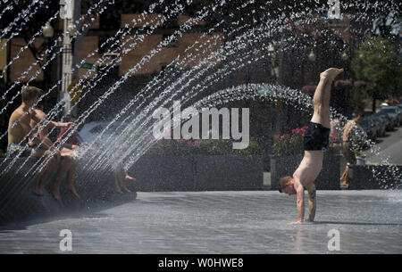 Les gens se rafraîchir dans une fontaine au Georgetown Waterfront Park, que les températures haut dans le milieu des années 90 pour la deuxième journée consécutive, à Washington, D.C. le 12 juin 2015. La capitale du pays est au milieu d'une mini vague alors que l'été les températures devraient rester élevé si la fin de semaine. Photo par Kevin Dietsch/UPI Banque D'Images