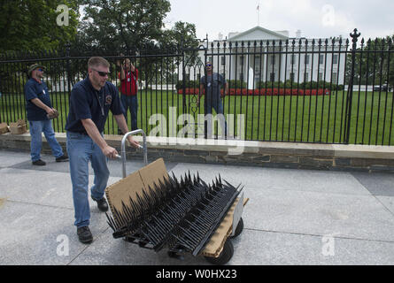 Installer d'autres travailleurs monte à la Maison Blanche clôture dans un effort pour empêcher les cavaliers de clôture, à Washington, D.C., juillet 1, 2015. Les pointes font partie de mesures temporaires visant à mettre fin à l'augmentation récente de cavaliers de clôture et autres intrus à la Maison Blanche. Kevin Dietsch/UPI Banque D'Images