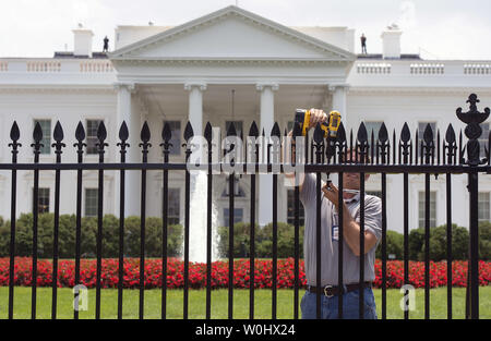 Les travailleurs d'un installe des monte à la clôture de la Maison blanche afin de dissuader les cavaliers de clôture, à Washington, D.C., juillet 1, 2015. Les pointes font partie de mesures temporaires visant à mettre fin à l'augmentation récente de cavaliers de clôture et autres intrus à la Maison Blanche. Kevin Dietsch/UPI Banque D'Images