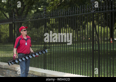 Les travailleurs d'un installe des monte à la clôture de la Maison blanche afin de dissuader les cavaliers de clôture, à Washington, D.C., juillet 1, 2015. Les pointes font partie de mesures temporaires visant à mettre fin à l'augmentation récente de cavaliers de clôture et autres intrus à la Maison Blanche. Kevin Dietsch/UPI Banque D'Images