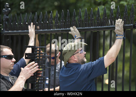 Installer d'autres travailleurs monte à la Maison Blanche clôture dans un effort pour empêcher les cavaliers de clôture, à Washington, D.C., juillet 1, 2015. Les pointes font partie de mesures temporaires visant à mettre fin à l'augmentation récente de cavaliers de clôture et autres intrus à la Maison Blanche. Kevin Dietsch/UPI Banque D'Images